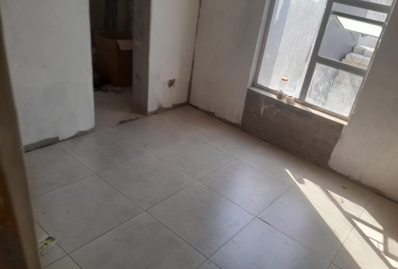 Newly tiled interior room with plastered walls ready for finishing