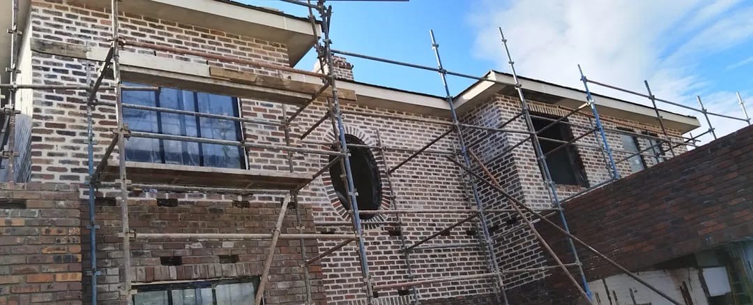 Scaffolding around a brick home during renovation work